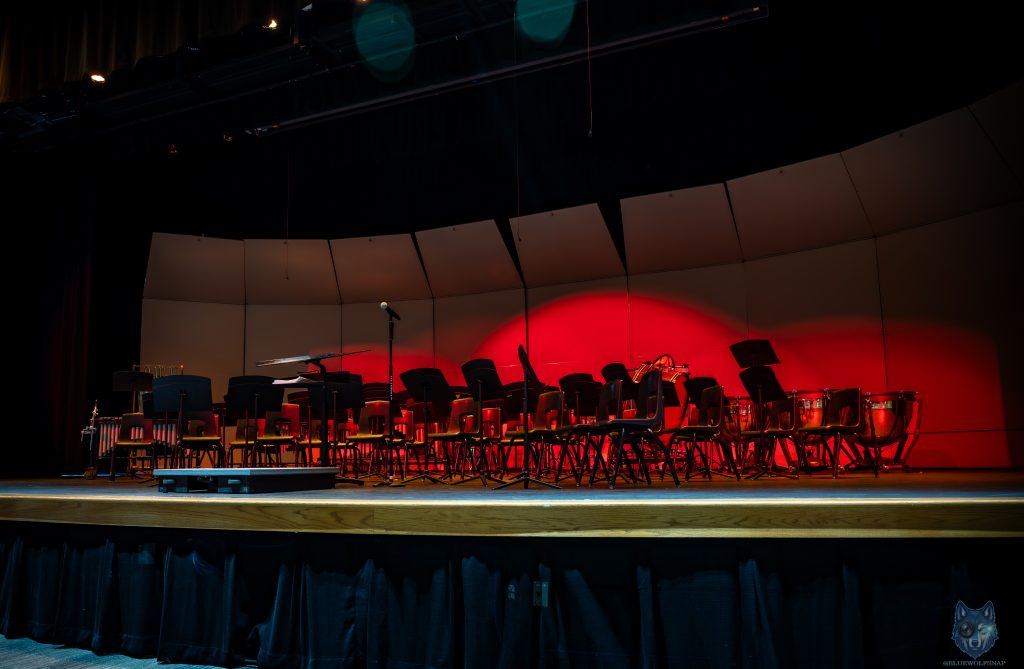 Empty concert stage with red spotlight and music stands before a performance, Jacobs High School Algonquin Illinois, Blue Wolf Snap